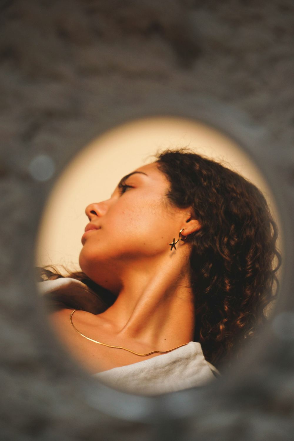 Woman with eyes closed in warm light, representing calm pelvic floor wellbeing